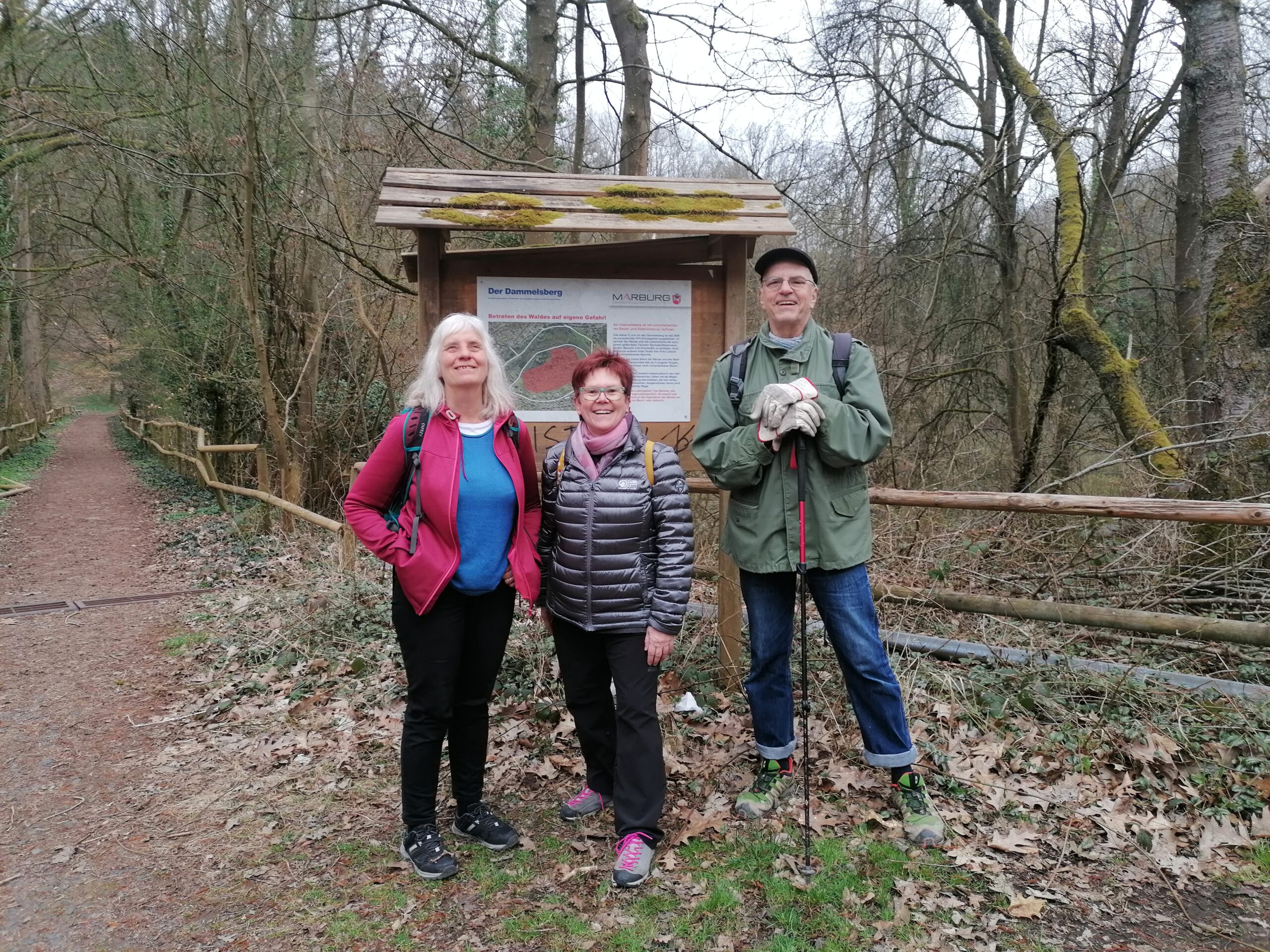 IMG_20250330_115018 Zwei Frauen und ein Mann stehen vor einer Wandertafel am Dammelsberg und lachten in die Kamera. Eine Frau und der Mann sind Blind, die dritte ist eine Freiwillige
