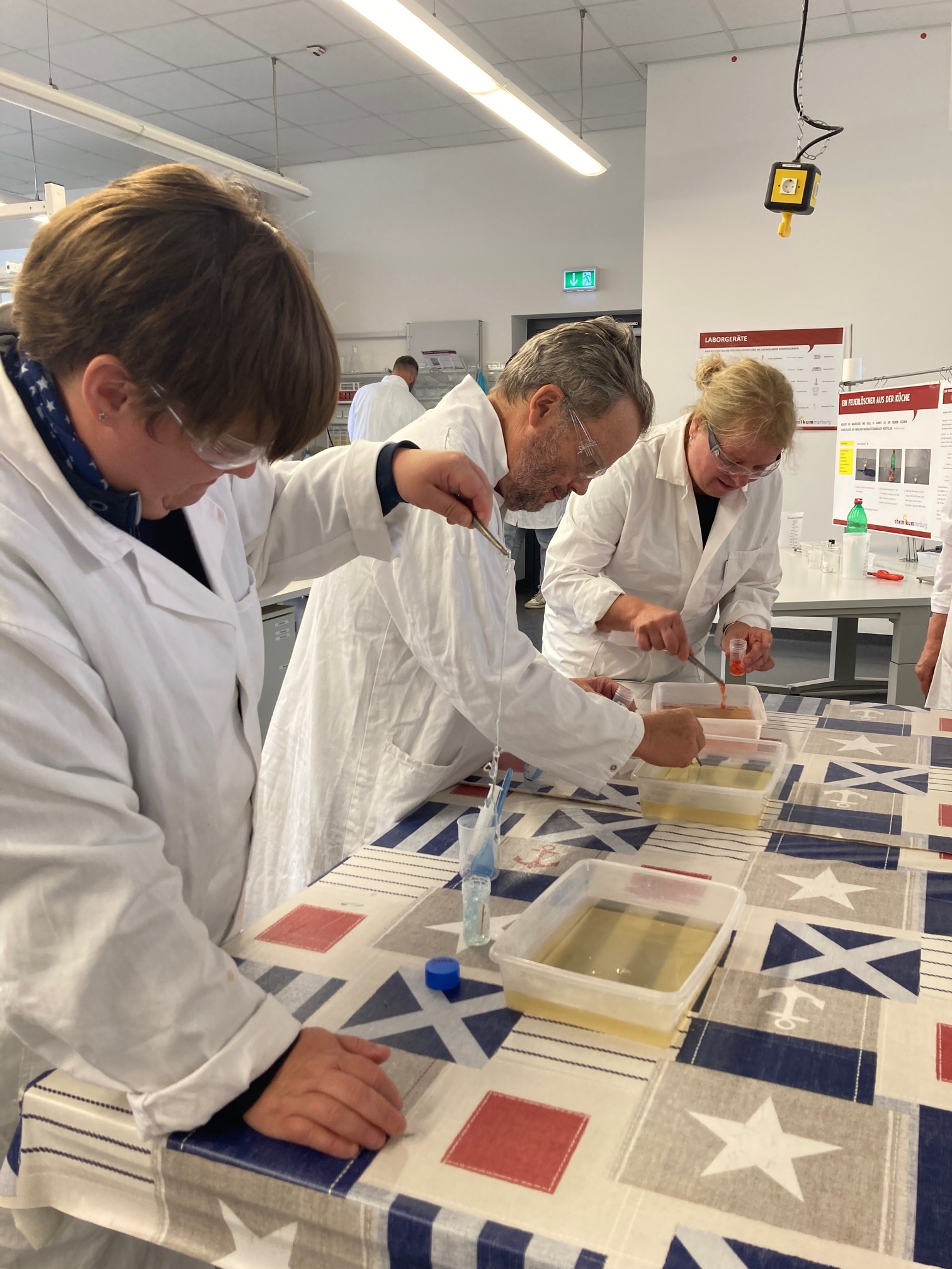 3 Personen experimentieren mit Pipetten und Flüssigkeiten